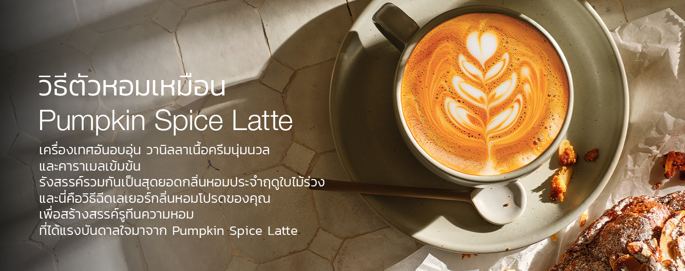 A pumpkin spice latte with latte art on a marble surface